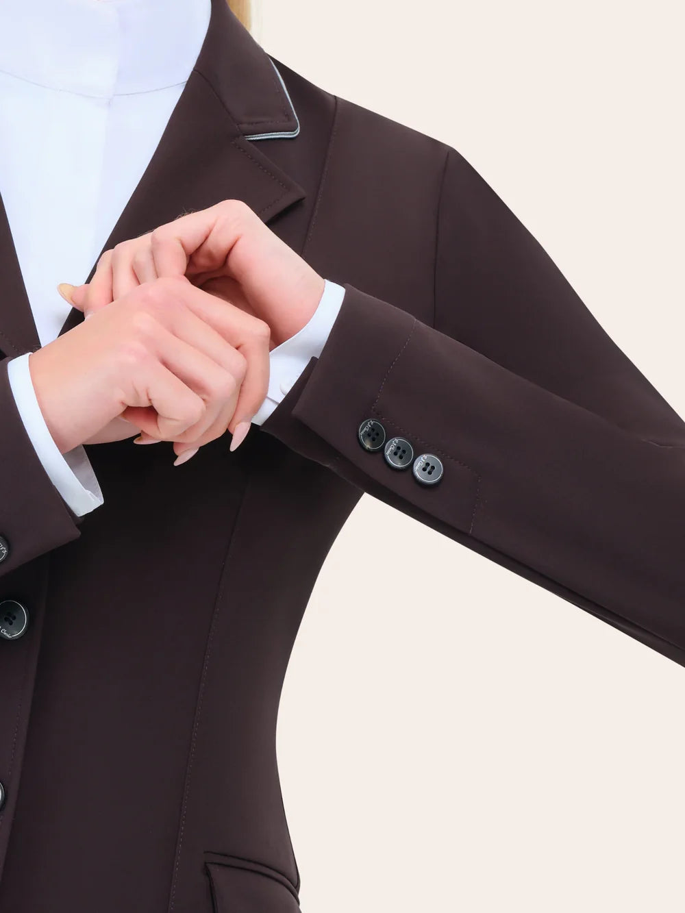 Close-up of the RJ Classics Monterey Show Coat in fig showing the notched lapel with contrast piping, smooth stretch fabric, and buttoned sleeve cuff over a white show shirt.