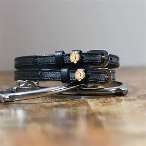 Front view of the buckled Monkey Faces Mane Jane Spur Straps on wood