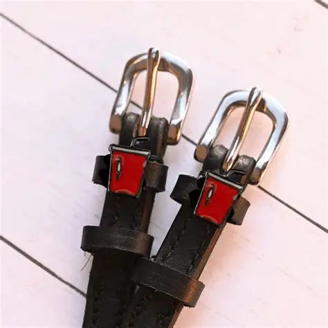 Close-up view of the buckled Soda Mane Jane Spur Straps on white wood