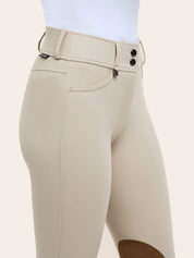 Close-up of the RJ Classics Olivia Luxe-Tek Breech in Sand showing the double-button waistband with belt loops, front pocket detail, and smooth stretch fabric above the brown suede knee patch.