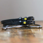 View of the Olive Mane Jane Spur Straps on a wooden surface