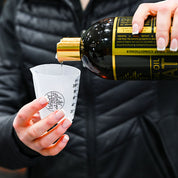 Close-up view of someone measuring out the Hairy Pony Essential Oil Coat Conditioner into a cup