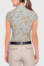 Back view of a female model wearing the vintage dove Kastel Cap Sleeve 1/4 Zip Sun Shirt on a plain background