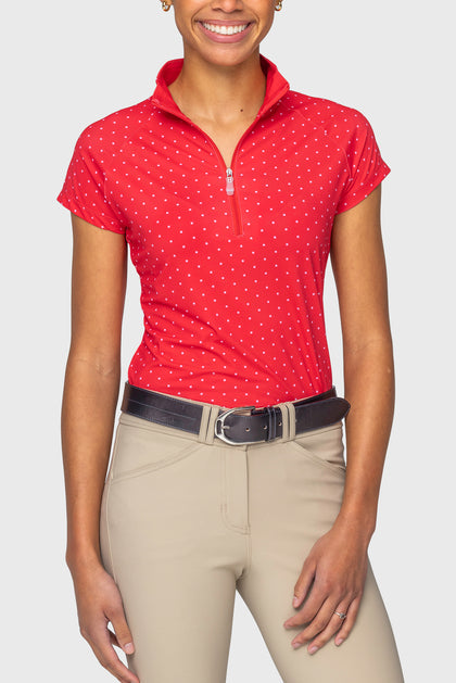 Front view of a female model wearing the red & pink swiss dot Kastel Cap Sleeve 1/4 Zip Sun Shirt on a plain background