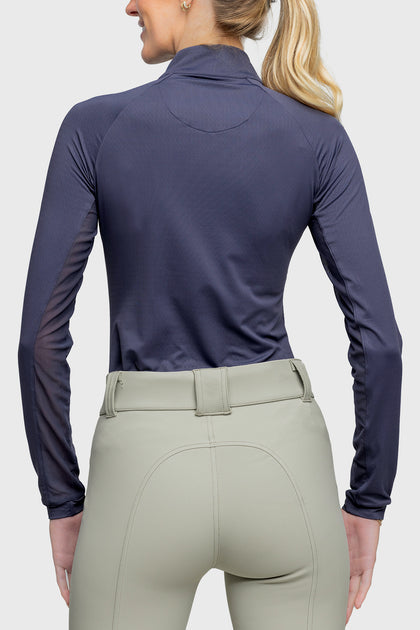 Back view of a female model wearing the Navy Rose Gold Zip Kastel 1/4 Zip Long Sleeve Sun Shirt on a plain background