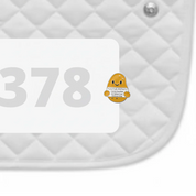 Side view of a white pad with numbers 378 and a Positive Potato Dubois Cheval Number Pin Charm on a white background