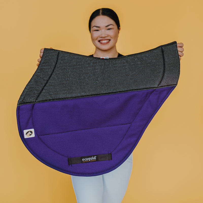 Side view of a model holding the purple Ecogold Secure Cross Country Pad on a yellow background