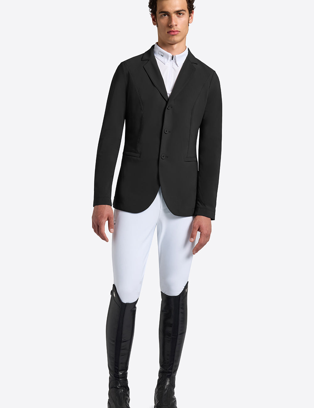 Rider’s Gene men’s black jersey competition jacket, front view, worn with white breeches and tall black riding boots