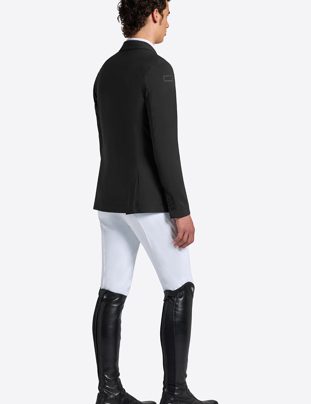 Rider’s Gene men’s black jersey competition jacket, side and back view, worn with white breeches and tall black riding boots