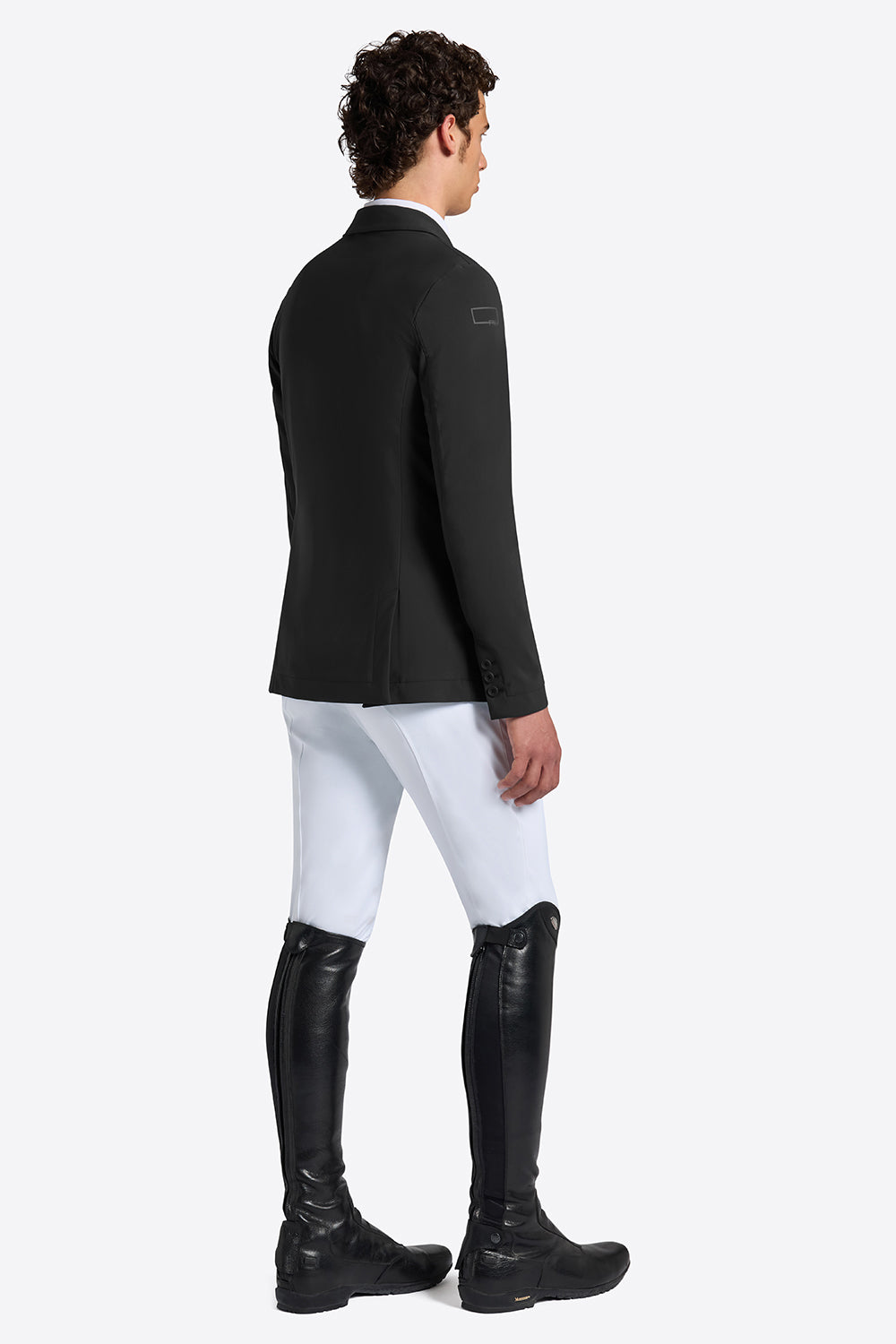 Rider’s Gene men’s black jersey competition jacket, side and back view, worn with white breeches and tall black riding boots