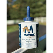 Front view of a 32 oz bottle of Mavrik Equine Hair, Coat & Scar Repair on a fence outside