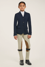 Full body front view of a young female model wearing the navy RJ Classics Kids Shore Show Coat and tan breeches on a plain background