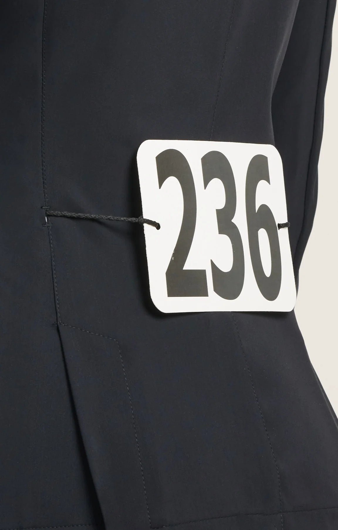 Close-up back view of a 236 competition number tabard over the black RJ Classics Kids Shore Show Coat