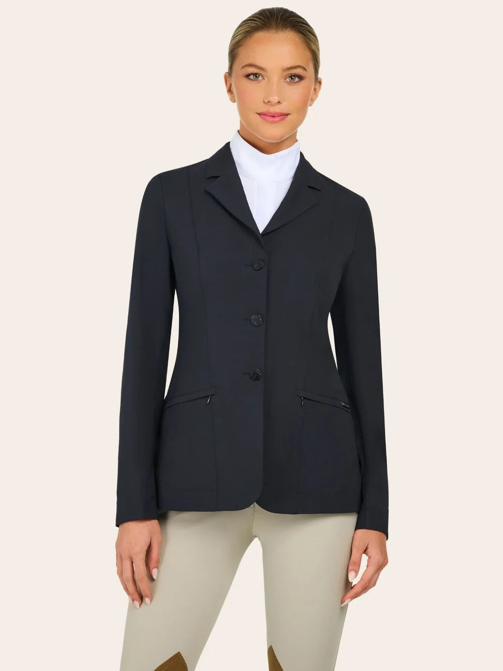 Front view of the RJ Classics Sloane Show Coat in black with a notched lapel, three-button front closure, and slanted zip pockets, worn over a white high-collar show shirt with tan breeches against a plain light background.