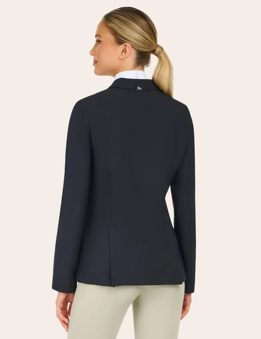 Back view of the RJ Classics Sloane Show Coat in black showing a fitted silhouette and center back vent, worn over a white show shirt with light tan breeches against a plain light background.