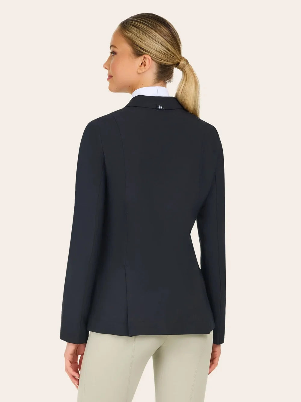 Back view of the RJ Classics Sloane Show Coat in black showing a fitted silhouette and center back vent, worn over a white show shirt with light tan breeches against a plain light background.