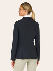 Back view of the RJ Classics Sloane Show Coat in black showing a fitted silhouette and center back vent, worn over a white show shirt with light tan breeches against a plain light background.