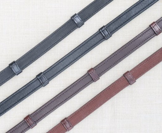 Side by side views of black and brown pairs of the KL Select Soft Grip Reins with Stops on a textured background