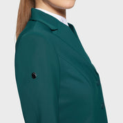 Close-up side view of a female model wearing the Hunter Green Samshield Alexia Show Coat on a plain background