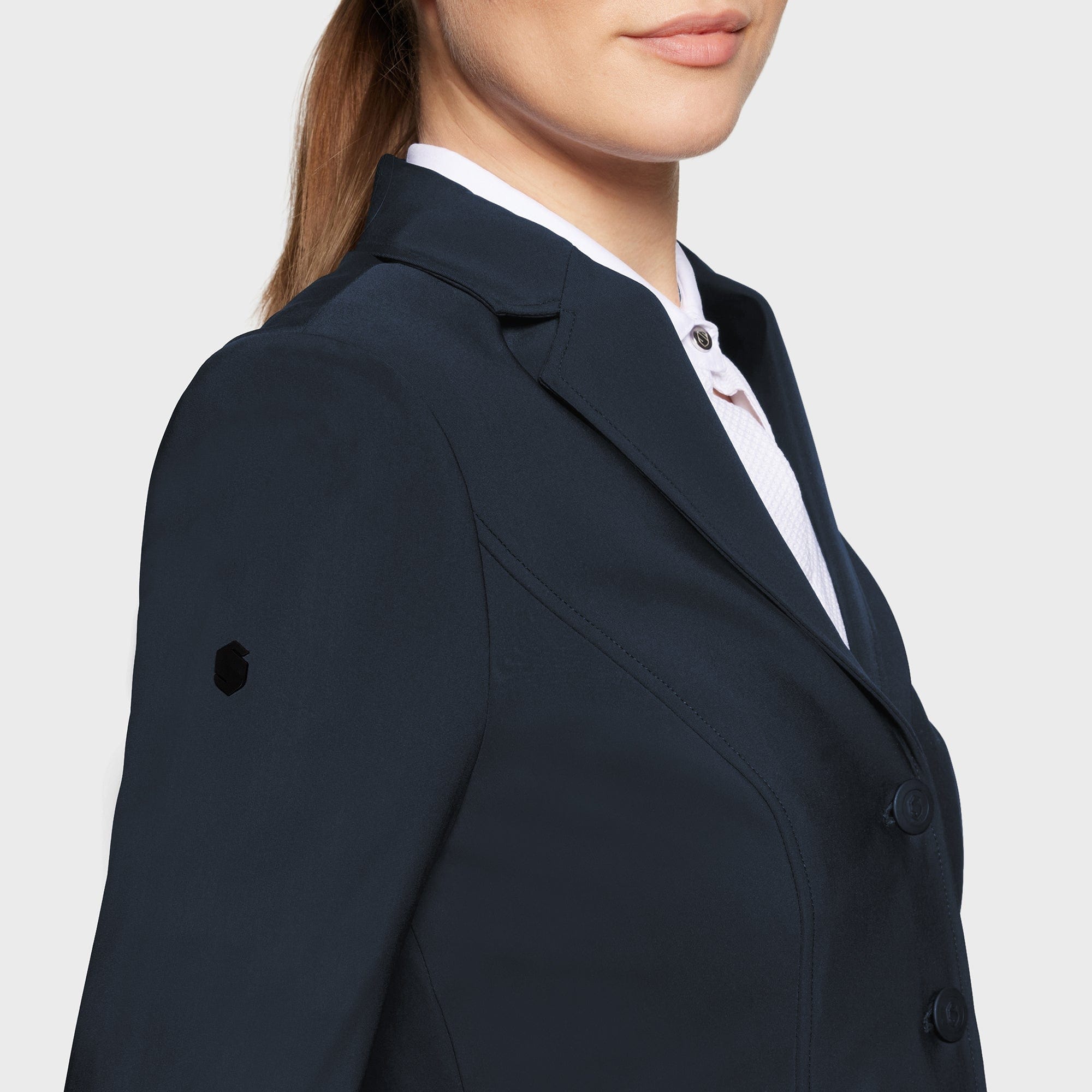 Close-up side view of a female model wearing the Navy Samshield Alexia Show Coat on a plain background
