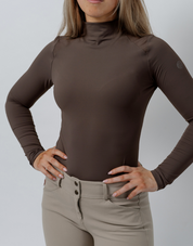 Front view of a female model wearing the Espresso TKEQ Chloe High Collar Technical Top on a plain background