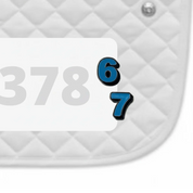 Side view of a white pad with numbers 378 and a pair of Six Seven Dubois Cheval Number Pin Charms on a white background