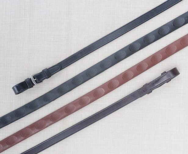 Side-by-side views of  black and brown pairs of Red Barn 5/8" Thumb Grip Reins on a patterned background