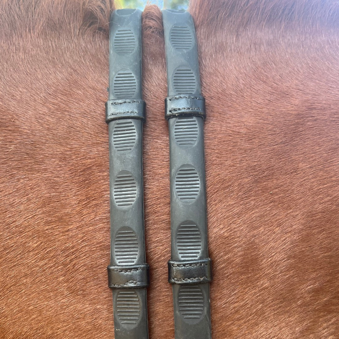 A pair of black Correct Connect Thumb Grip Reins on a chestnut horse's neck