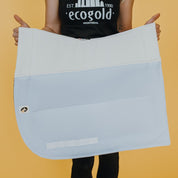 View of a model holding the white Ecogold Secure Dressage Pad on a yellow background