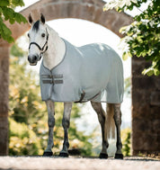 Horse wearing Horseware Amigo Airnet Cooler in light grey standing outdoors