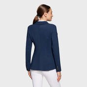 Back view of a model wearing the navy blue Samshield Alix Show Coat on a plain background