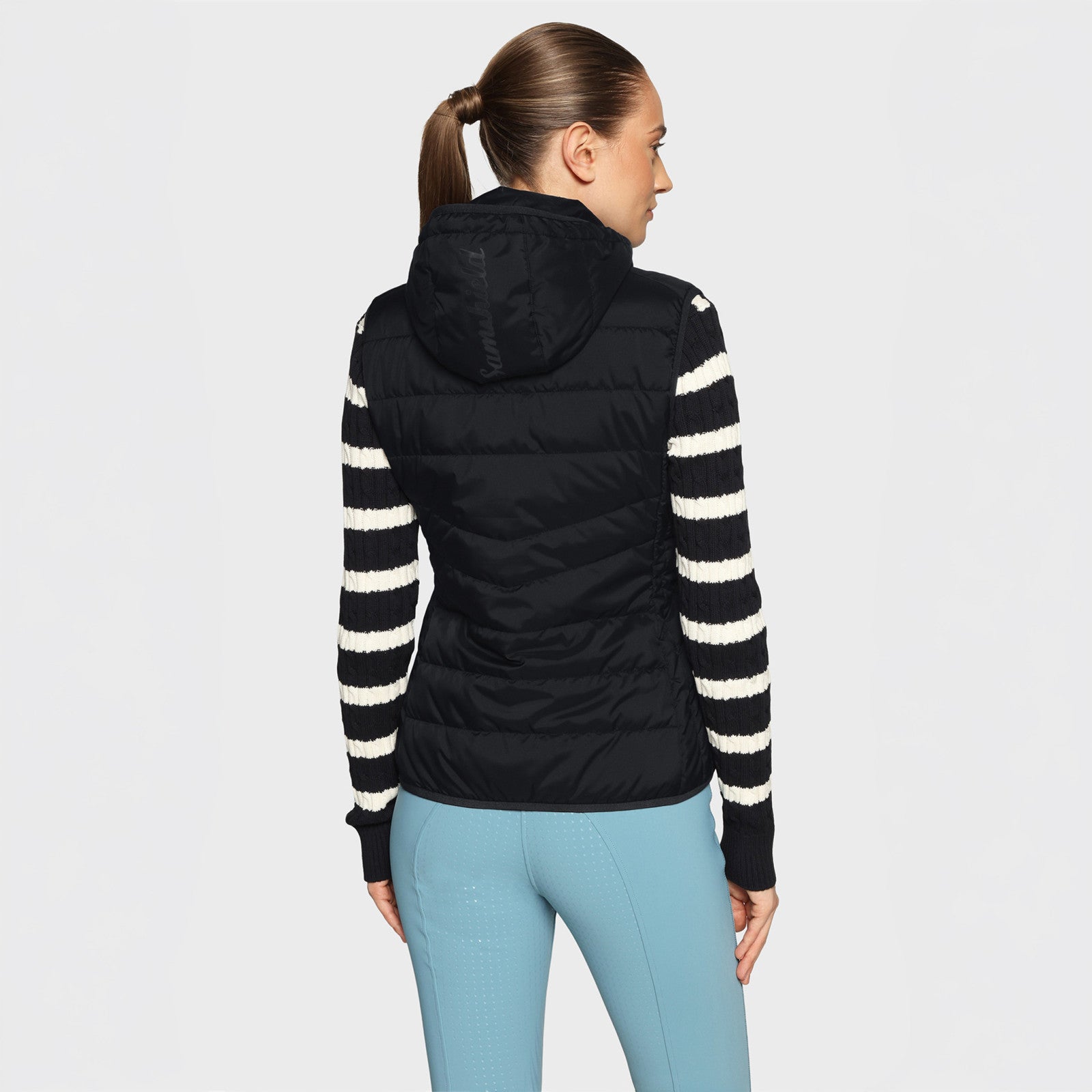 Back view of a female model wearing the black Samshield Alta Badia Vest on a plain background