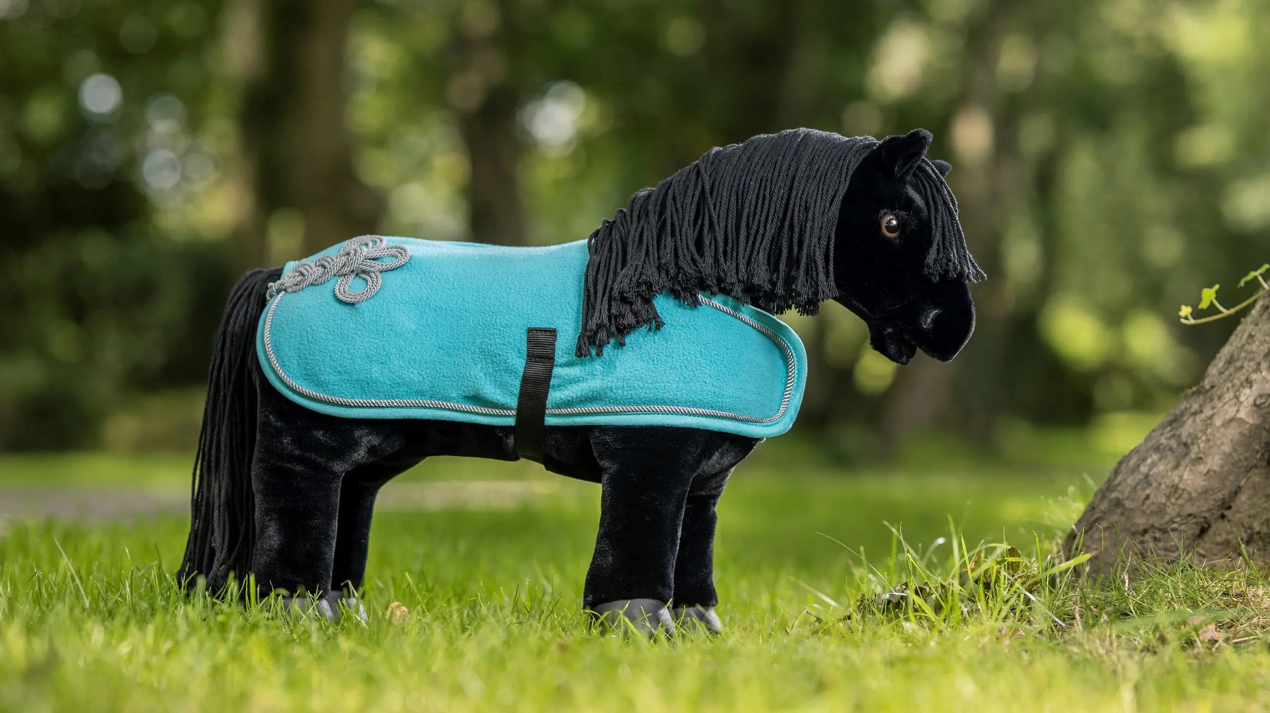 Aqua toy fleece cooler on a black stuffed animal horse outside