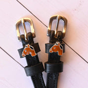 Close-up view of the Bay Horse Mane Jane Spur Straps on a white wood plank background
