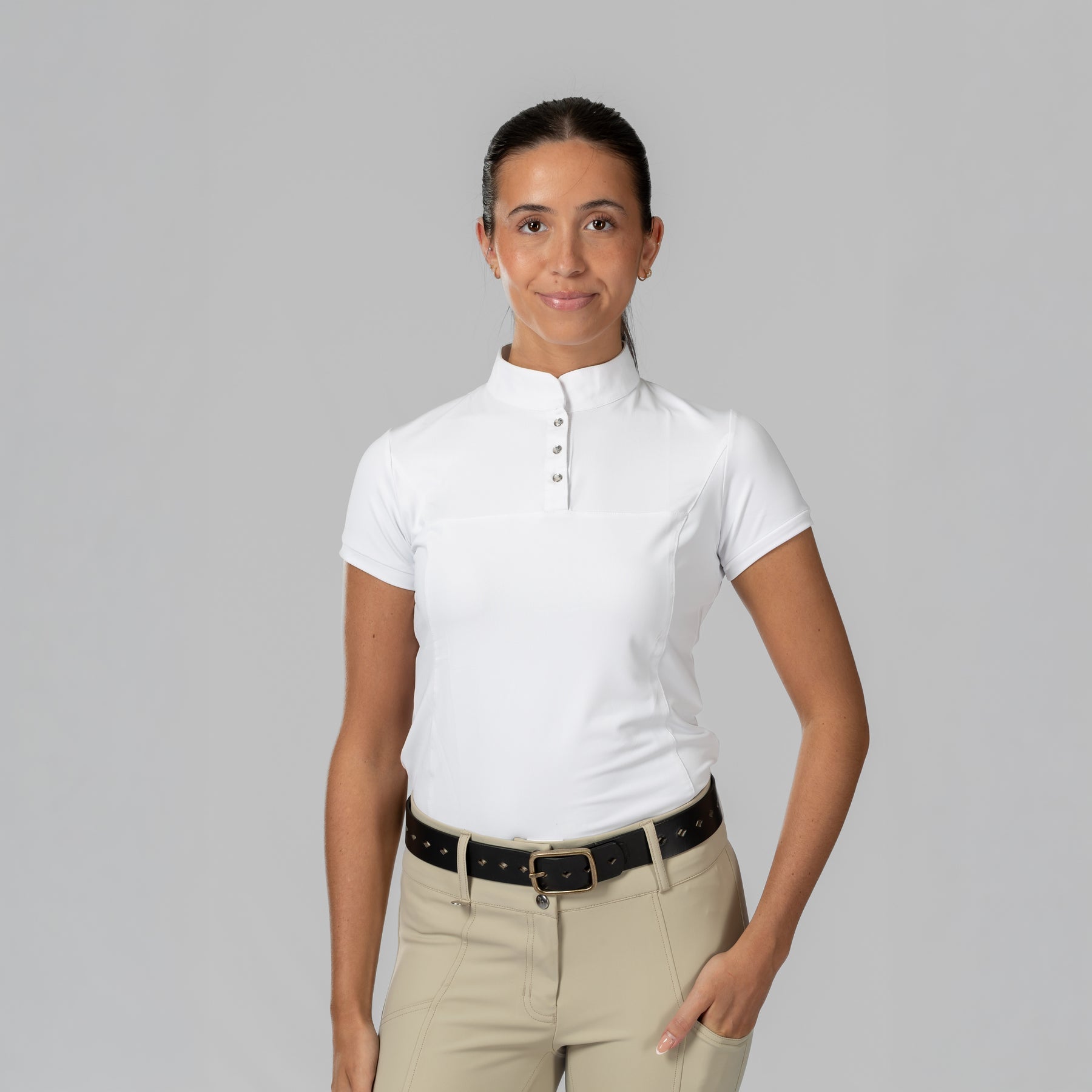 Front view of a female model wearing the white Horze Mina Short Sleeve Crystal Show Shirt on a plain background