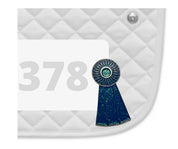 Side view of a white pad with numbers 378 and a Blue Ribbon Dubois Cheval Number Pin Charm on a white background