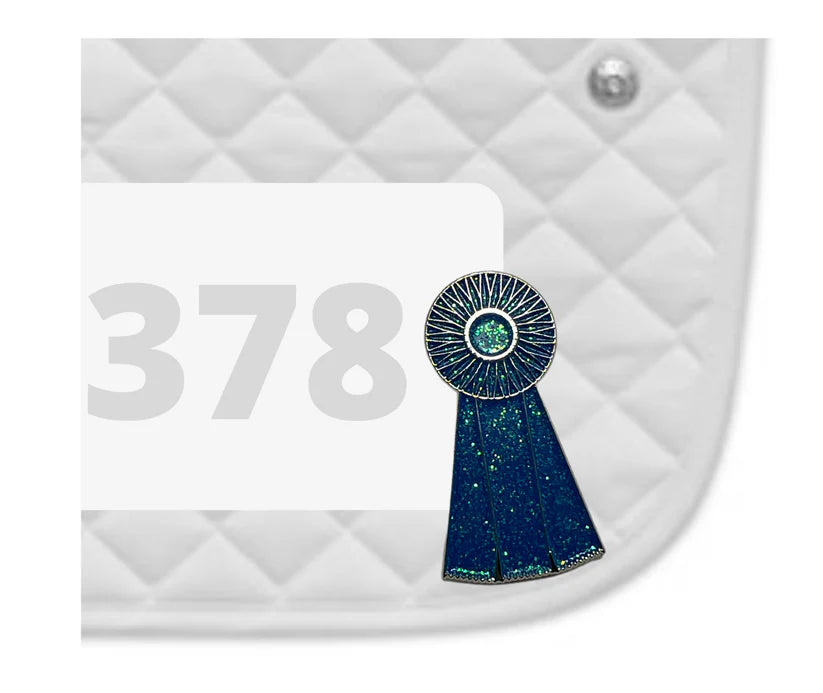 Side view of a white pad with numbers 378 and a Blue Ribbon Dubois Cheval Number Pin Charm on a white background