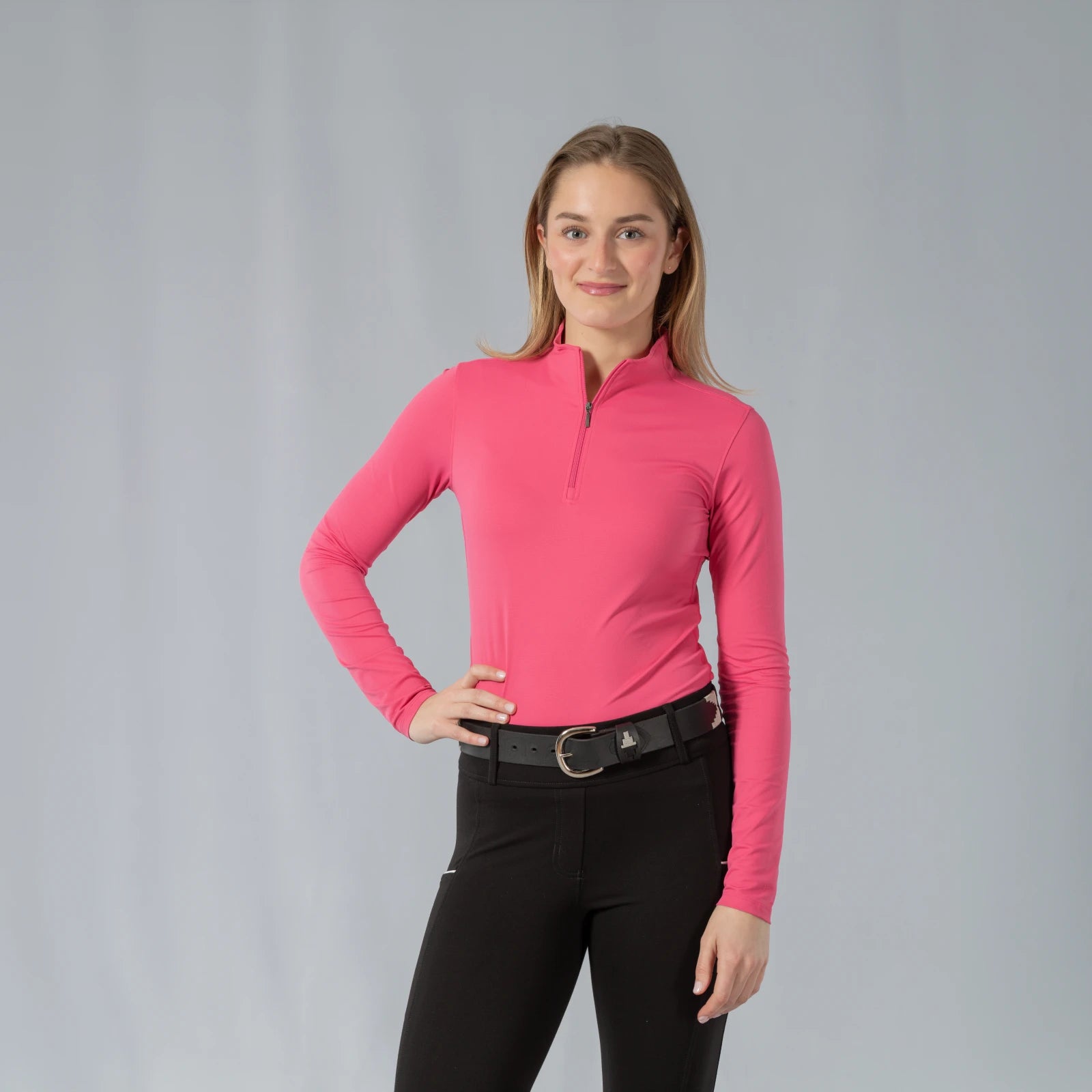Front view of a model wearing the Equinavia Kari Womens Long Sleeve Sun Shirt with NordicAir Tech in pink on a gray background