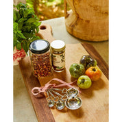 View of the Blue Stallion Farm Equestrian Zinc Measuring Spoons with veggies and spices on a wooden cutting board