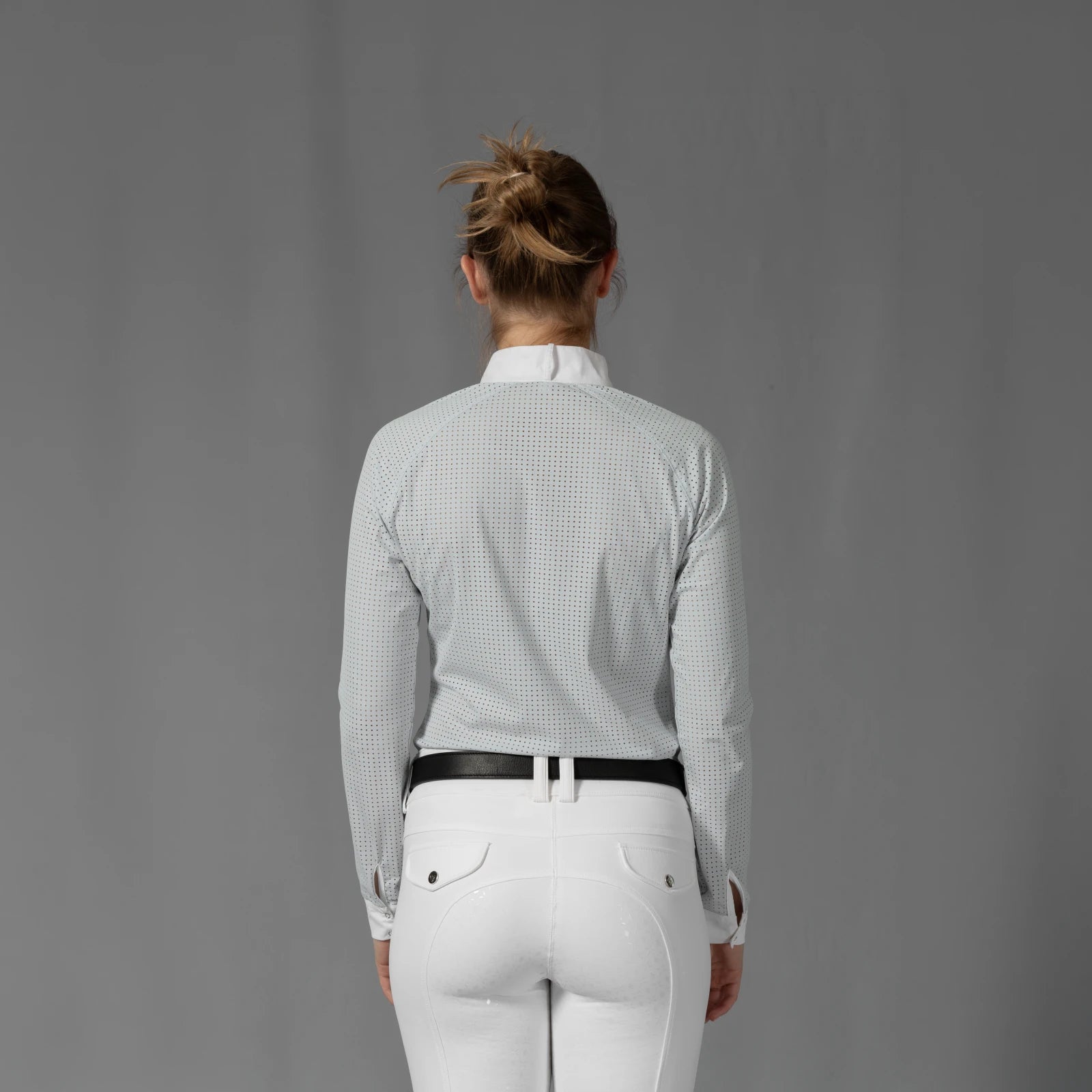 Back view of a model wearing the Equinavia Sara Womens Perforated Long Sleeved Show Shirt in light blue and white on a gray background