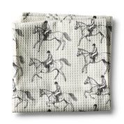 Front view of a folded black & white equestrian Canary Road Kitchen Towel on a white background