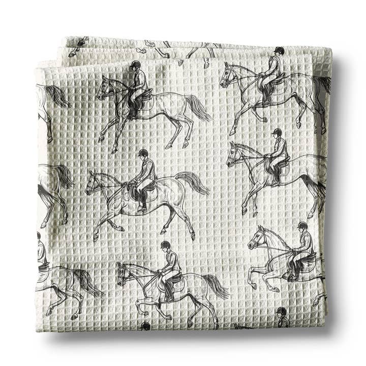 Front view of a folded black & white equestrian Canary Road Kitchen Towel on a white background