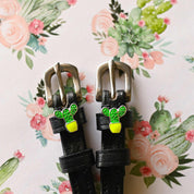Close-up view of the Cactus Mane Jane Spur Straps on a pink floral cactus background