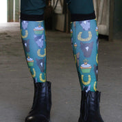 Front view of a model wearing the Carrot Cake Dreamers & Schemers Pair & A Spare Boot Socks while standing in a barn aisle