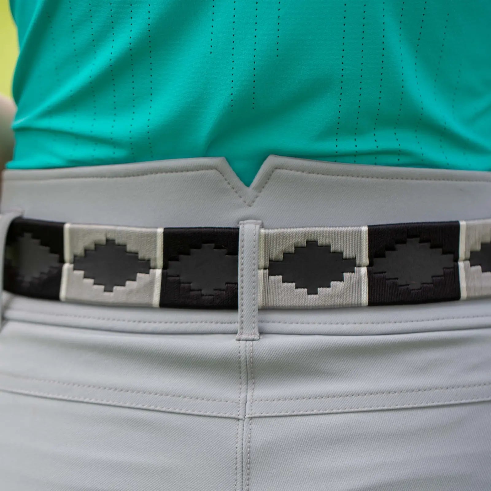 Close-up view of the gray and black, black-leather Equinavia Siri Polo Belt on gray breeches