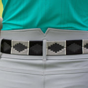 Close-up view of the gray and black, black-leather Equinavia Siri Polo Belt on gray breeches