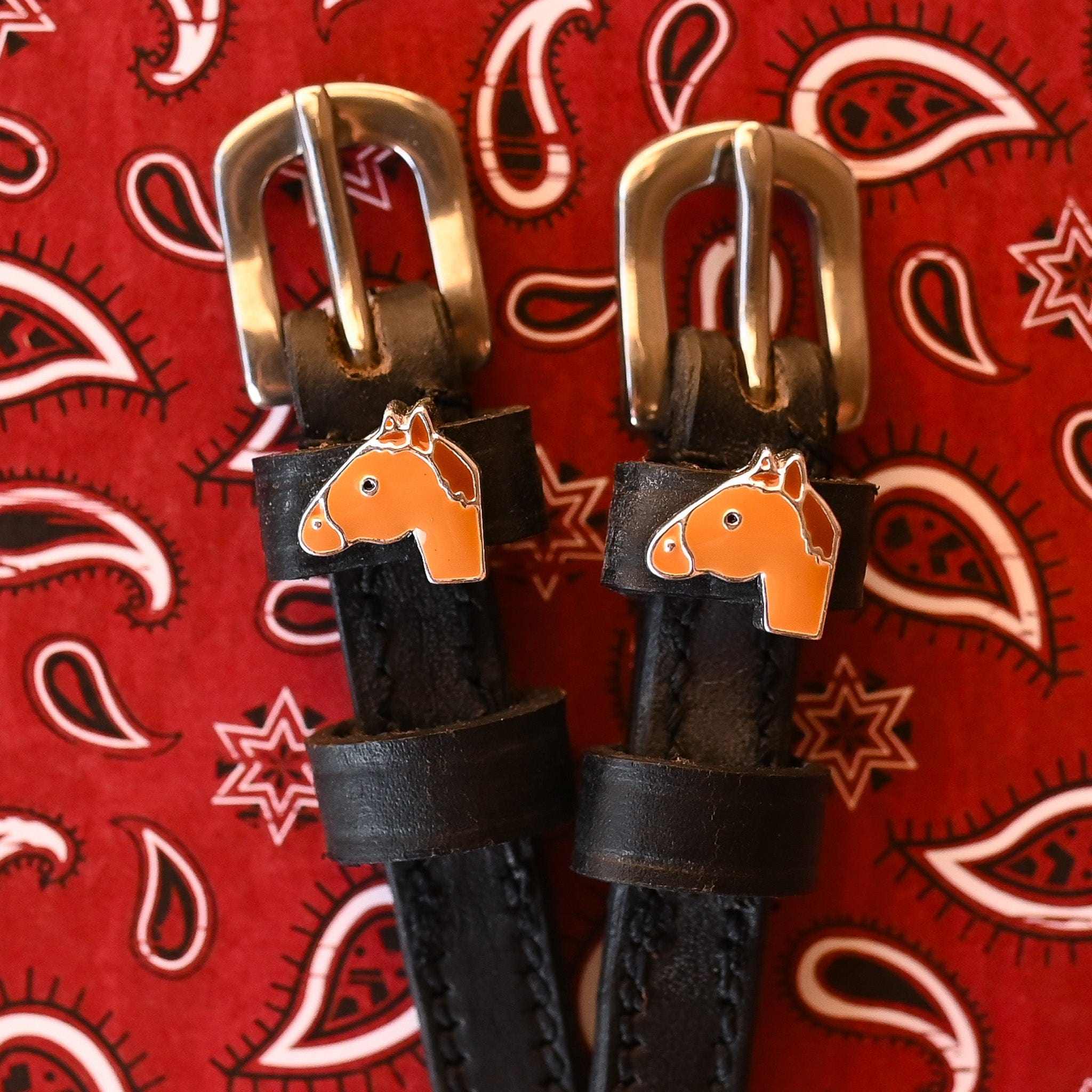 Close-up view of the Chestnut Horse Mane Jane Spur Straps on a red paisley bandana