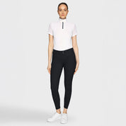 Full body front view of a female model wearing the black Samshield Clara Premium Full Grip Breeches with a white top on a plain background