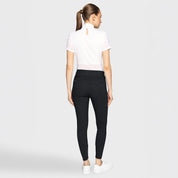 Full body back view of a female model wearing the black Samshield Clara Premium Full Grip Breeches and white top on a plain background