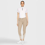 Full body front view of a female model wearing the sand Samshield Clara Premium Knee Grip Breeches and white shirts on a plain background